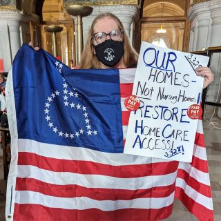 Woman holding American flag with stars in the shape of "handicapped" symbol